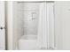 Clean bathroom with white tub, shower, and textured tile walls, providing a fresh and modern look at 403 Mayodan Dr, Cary, NC 27511