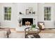 Close-up of a charming white brick fireplace in a cozy living room with decor at 403 Mayodan Dr, Cary, NC 27511