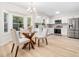 Eat-in kitchen with stainless steel appliances, white cabinets, and a glass top dining table at 403 Mayodan Dr, Cary, NC 27511