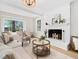 Bright living room with a white brick fireplace and large windows overlooking the yard at 403 Mayodan Dr, Cary, NC 27511