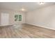Spacious living room with durable floors, natural light from the window, and a white door at 411 A Aversboro Rd, Garner, NC 27529