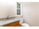 Bathroom features a vanity with granite countertop, window and white toilet at 411 B Aversboro Rd, Garner, NC 27529
