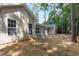 View of the back of a tan home with white windows, a concrete porch, and sparse landscaping at 411 B Aversboro Rd, Garner, NC 27529