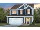 Charming two-story home featuring a white garage door, black shutters, and a well-maintained lawn at 433 Providence Springs Ln, Fuquay Varina, NC 27526