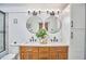 Bright bathroom featuring double sinks, stylish lighting, round mirrors, and modern fixtures at 4513 Denfield St, Durham, NC 27704