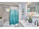 Bathroom features a tub and shower, double sinks, and modern blue curtain at 4513 Denfield St, Durham, NC 27704