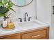 Close-up of bathroom's quartz countertop, double sinks, bronze faucets, and modern décor at 4513 Denfield St, Durham, NC 27704
