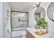 Well-lit bathroom features a shower with glass doors, double sinks, round mirrors, and modern fixtures at 4513 Denfield St, Durham, NC 27704
