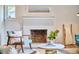 Cozy fireplace with painted brick and a decorative mantle in a sunlit living room at 4513 Denfield St, Durham, NC 27704