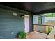 Inviting front porch features wood decking, gray brick siding, and a pink front door at 4513 Denfield St, Durham, NC 27704