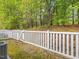 Backyard showcasing a white fence and an open gate with tree views at 522 Auburn Square Dr, Durham, NC 27713