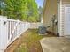 Side of home with white fence, open gate, and an external AC unit on a concrete slab at 522 Auburn Square Dr, Durham, NC 27713