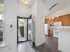 Bright entryway view into the kitchen featuring wooden cabinets and white appliances at 522 Auburn Square Dr, Durham, NC 27713