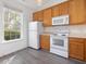 A well lit kitchen with stainless steel microwave, stove, and wood cabinets at 522 Auburn Square Dr, Durham, NC 27713