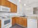 Open-concept kitchen offers wood cabinets and white appliances at 522 Auburn Square Dr, Durham, NC 27713