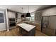Modern kitchen featuring stainless steel appliances, gray cabinets, hardwood floors and a large kitchen island at 524 Folk Song Way, Wendell, NC 27591