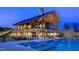 Stunning pool area with a spacious deck, umbrellas, and elegant clubhouse in the background at 524 Folk Song Way, Wendell, NC 27591
