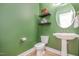 Stylish half bathroom featuring a pedestal sink and floating shelves for storage at 528 Holden Forest Dr, Youngsville, NC 27596
