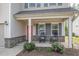 Charming front porch with rocking chairs, brick accents, a red front door, and meticulously maintained landscaping at 528 Holden Forest Dr, Youngsville, NC 27596