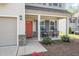 Inviting front porch featuring a bright red door, rocking chairs, and manicured landscaping details at 528 Holden Forest Dr, Youngsville, NC 27596