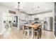 Spacious kitchen with stainless steel appliances, white cabinets, an island with seating, and modern lighting at 528 Holden Forest Dr, Youngsville, NC 27596