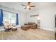 Cozy living room with a leather sofa, accent chair, ceiling fan, and wood-look flooring at 528 Holden Forest Dr, Youngsville, NC 27596