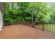 A large wood deck with natural views and railing is perfect for entertaining and relaxing at 5604 Groomsbridge Ct, Raleigh, NC 27612