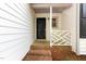 Close up of front door featuring a black door, brick trim and the house numbers displayed on a white fence at 5604 Groomsbridge Ct, Raleigh, NC 27612