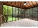 Screened porch with wood floors, ceiling fan, and view of the private, wooded backyard at 5604 Groomsbridge Ct, Raleigh, NC 27612