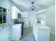 Well-lit kitchen with stainless steel sink, black appliances, island, and white cabinetry at 5828 Brambleton Ave, Raleigh, NC 27610