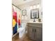 Bathroom features a tub and shower, toilet, vanity and sink with a gray vanity and colorful shower curtain at 6 Landover Ct, Durham, NC 27713