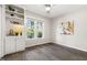 Bright bedroom with a built-in shelving unit, hardwood floors, a ceiling fan, and natural light from the windows at 6 Landover Ct, Durham, NC 27713