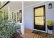 Cozy front porch with seating, shutters, and a stylish black door at 6 Landover Ct, Durham, NC 27713