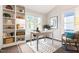 Bright home office features built-in shelving, a stylish rug, and plenty of natural light from large windows at 6 Landover Ct, Durham, NC 27713