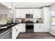 Bright kitchen features stainless steel appliances, white cabinetry, subway tile backsplash, and hardwood floors at 6 Landover Ct, Durham, NC 27713
