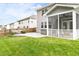 A well-maintained backyard featuring a screened porch, a patio with seating, and a lush green lawn at 609 Conover Rd, Durham, NC 27703