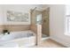 Bright bathroom features a tub, tiled shower, and a large window that provides ample natural light at 609 Conover Rd, Durham, NC 27703