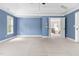 Spacious carpeted bedroom with bright blue walls and a hallway to another room at 609 Conover Rd, Durham, NC 27703