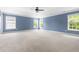 Large, carpeted bedroom with bright blue walls and abundant natural light from multiple windows at 609 Conover Rd, Durham, NC 27703
