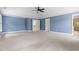 Expansive carpeted bedroom with a tray ceiling, bright blue walls, and access to other rooms at 609 Conover Rd, Durham, NC 27703