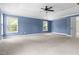 Large, carpeted bedroom with bright blue walls, ample natural light, and a tray ceiling at 609 Conover Rd, Durham, NC 27703