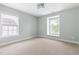 Bright bedroom with carpet floors and two windows providing natural light and outdoor views at 609 Conover Rd, Durham, NC 27703