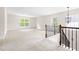 Spacious bonus room with neutral carpet, plenty of natural light, and stairs leading to a lower level at 609 Conover Rd, Durham, NC 27703