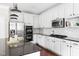 Contemporary kitchen featuring white cabinets, stainless steel appliances, and a dark granite island at 609 Conover Rd, Durham, NC 27703
