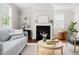 Cozy living room featuring a fireplace, wood floors, and comfortable gray sofa at 609 Conover Rd, Durham, NC 27703