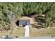 A tranquil aerial view shows a house backing onto a forest and featuring a manicured lawn and long concrete driveway at 61 Okra Ct, Selma, NC 27576