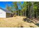 Exterior view of home and wooden deck in a large grassy backyard, with ample trees at 61 Okra Ct, Selma, NC 27576