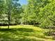 Spacious backyard featuring lush green grass and mature trees, offering privacy and tranquility at 6212 Trevor Ct, Raleigh, NC 27613
