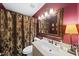 Bathroom with red walls, ornate mirror, vanity, toilet, and shower with decorative curtain at 6212 Trevor Ct, Raleigh, NC 27613