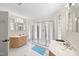 Bright bathroom featuring tiled floors, glass block windows, dual vanities, and a modern glass enclosed shower at 6212 Trevor Ct, Raleigh, NC 27613